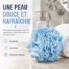 Fleur de douche bleue posée sur le marbre à côté d'une serviette blanche roulée