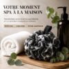 Fleur de douche noire posée sur une planche en bois, entre une serviette blanche et de l'eucalyptus