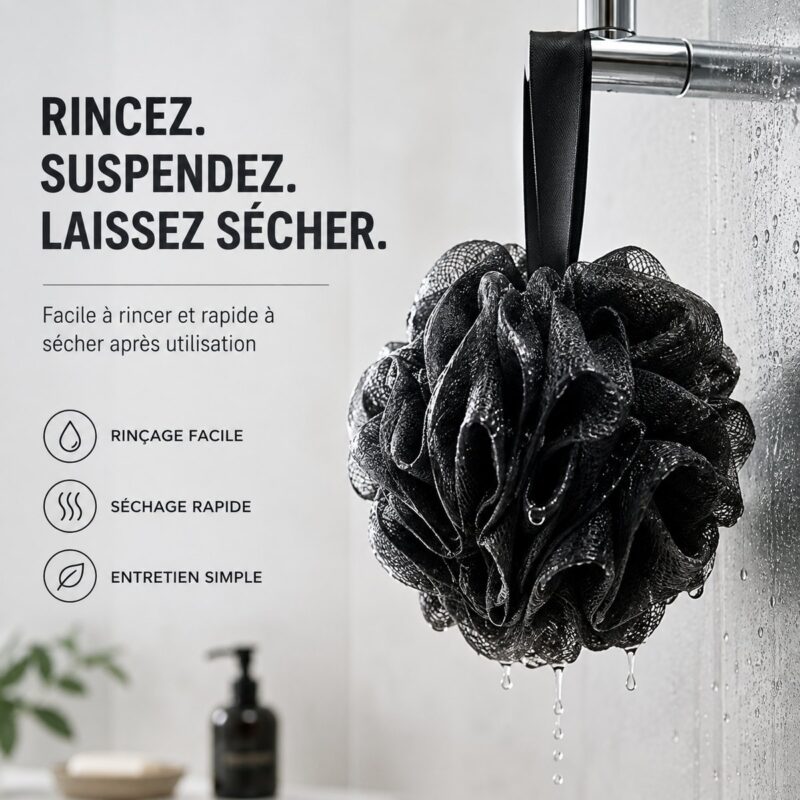 Fleur de douche noire suspendue par son ruban, elle s&rsquo;égoutte contre la paroi de douche